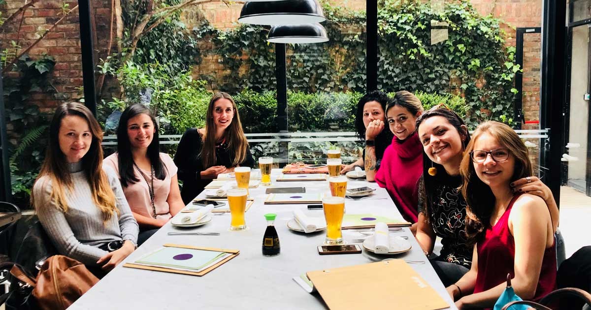 grupo de chicas en una mesa de un restaurante sonriendo a cámara